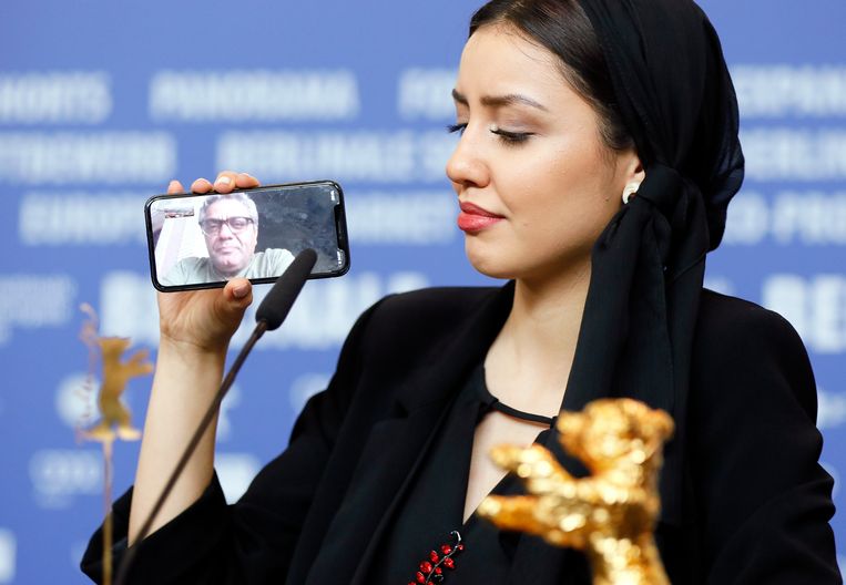 Baran Rasoulof, de dochter van regisseur Mohammad Rasoulof, neemt in Berlijn voor haar vader (op de telefoon) de Gouden Beer in ontvangst.  Beeld EPA