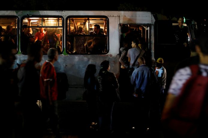 In het donker nemen mensen de bus tijdens de stroomuitval in Venezuela.