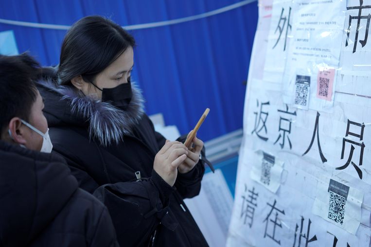 Mensen scannen een QR-code om hun risicoprofiel door te geven terwijl ze Beijing betreden. Beeld REUTERS