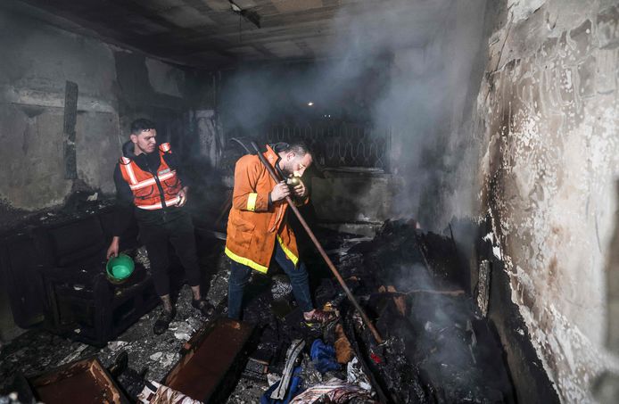 Palestijnse brandweermannen proberen het vuur in een van de appartementen te bedwingen.