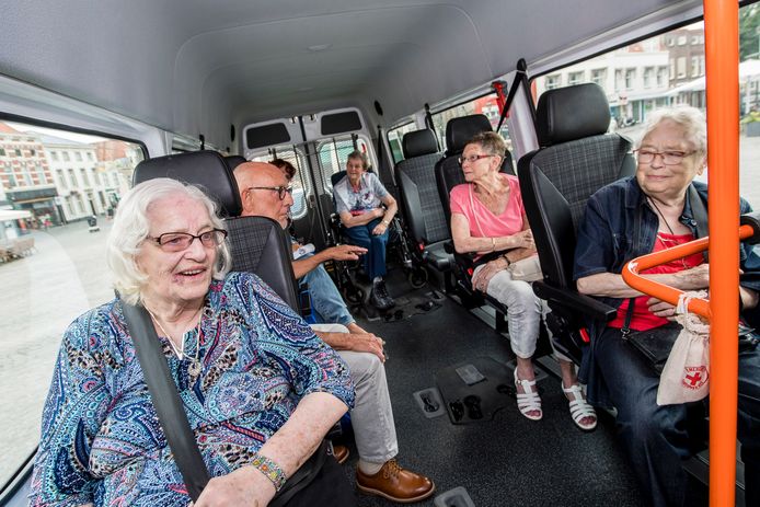 Vrijwilliger Ran de Clerck (2e van links)  neemt bewoners mee naar plaatsen waar ze
herinneringen aan hebben. Foto: v.l.n.r. : Jeanet van Dam, Ran de Clerck, Ria de Wolf (rolstoel), Annie van Bennaars, Antoinet van Broekhoven, in het busje op de markt waar Ran op dat moment tekst en uitleg geeft over het oude Stadhuis en de betekenis van de beelden.