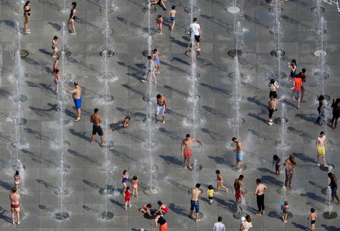 Mensen zoeken de koelte op van de vele fonteinen in Parijs.