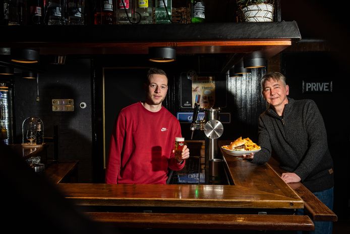 Ramon de Klein achter de tap en Michel Hovenkamp met een Maas ne Waal burger en friet.