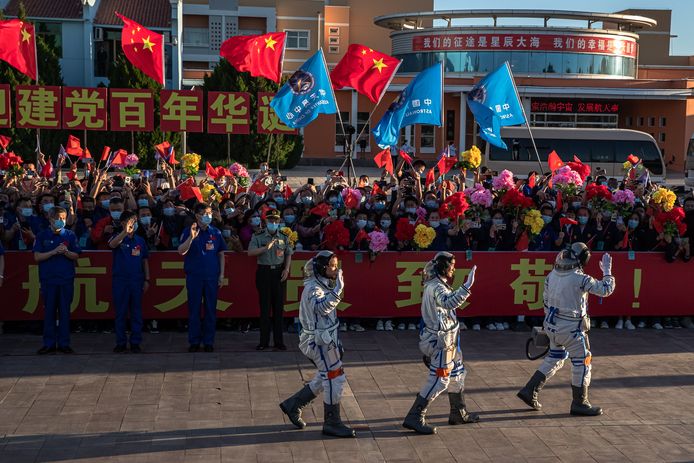 De Chinese astronauten Tang Hongbo, Nie Haisheng, en Liu Boming zwaaien tijdens een vertrekceremonie voorafgaande aan hun ruimtevlucht naar het Hemels Paleis 'Tiangong', het eerste echte ruimtestation van het land.