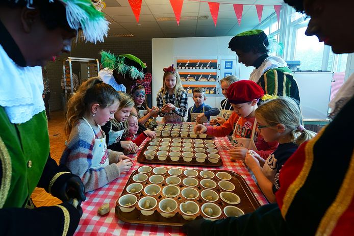 Kinderen mogen Bakpiet helpen met cupcakes maken voordat die in de oven gaan.