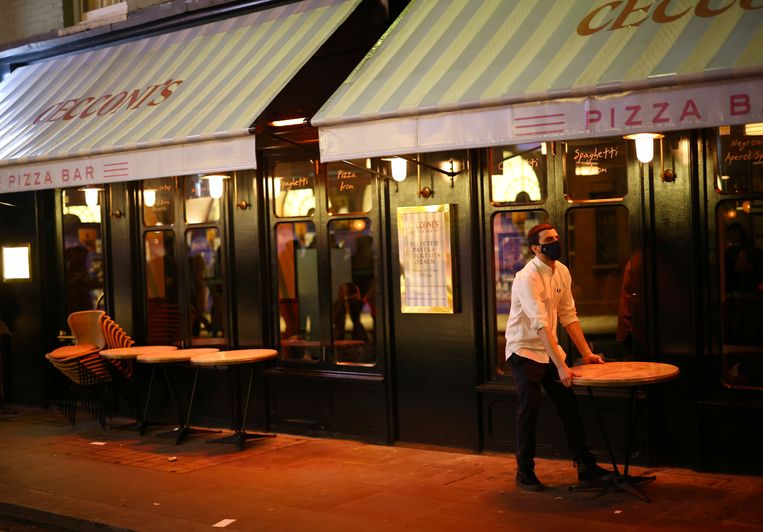 Een barman zet het laatste tafeltje weg voor sluiting. Beeld REUTERS