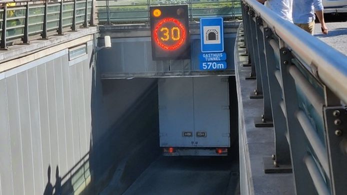 De kleine vrachtwagen reed zich klem in de tunnel.