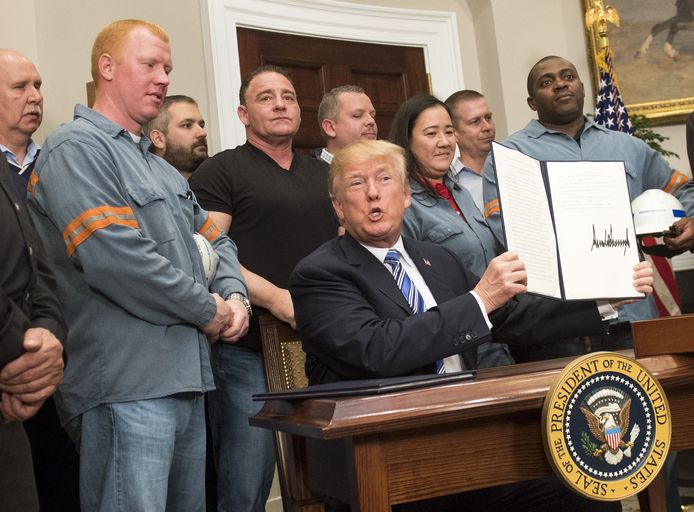 Amerikaans president Donald Trump tekent in het bijzijn van staalarbeiders de drastische tariefsverhogingen.