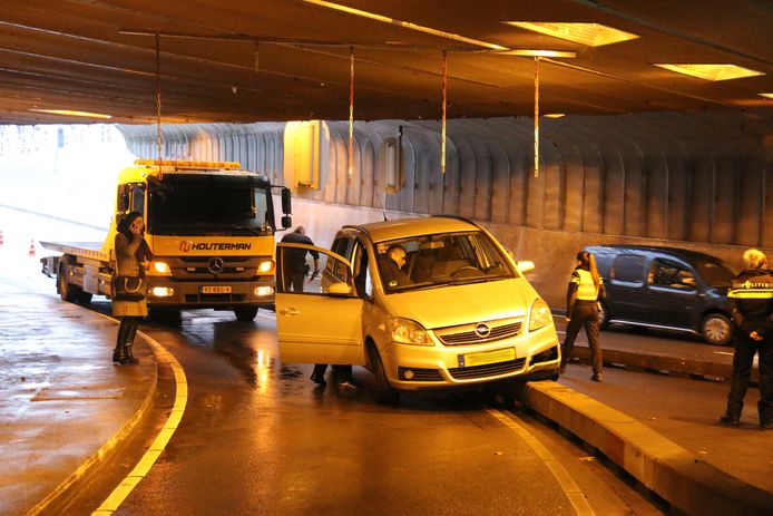 Auto rijdt tegen betonnen wegafscheiding in de Willemstunnel.
