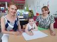Ulyana in haar klas, met links op de foto juf Maria en rechts mama Tatjana.