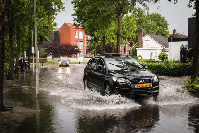 2018-05-29 20:15:54 KRUININGEN - Een auto rijdt door een ondergelopen straat ontstaan door zware onweersbuien. ANP GINOPRESS