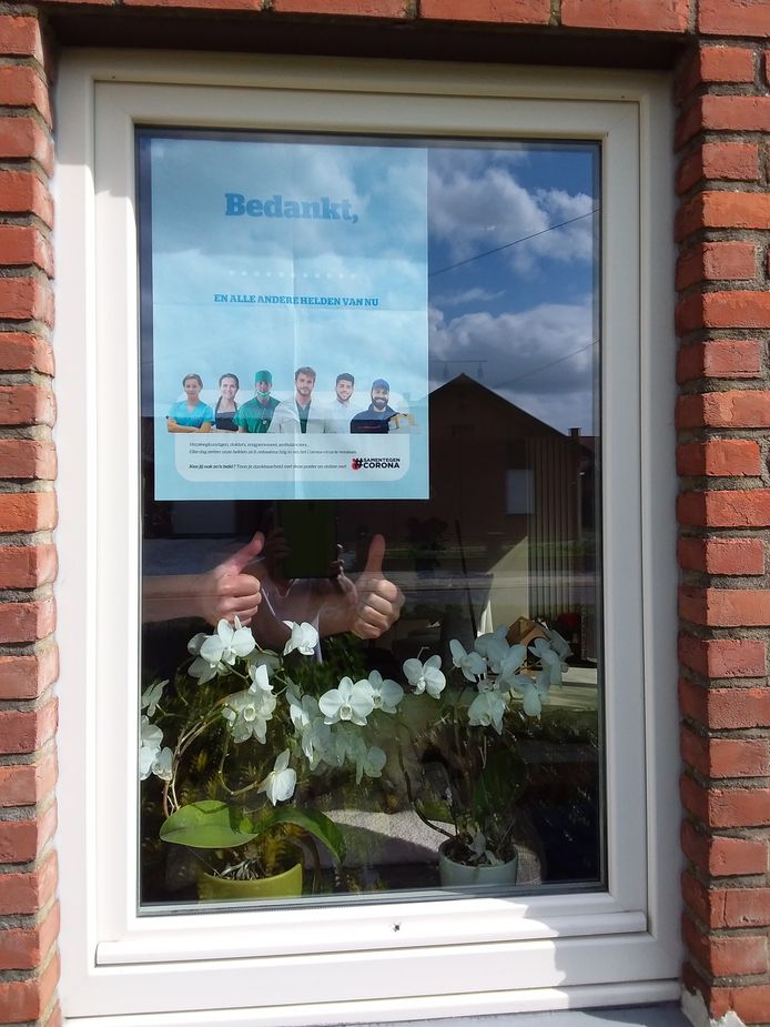 Een poster van twee verpleegkundigen die in het Ziekenhuis Oost-Limburg werken. Zij kunnen hun collega's helaas niet steunen wegens isolatie, maar met de posters drukken ze alsnog hun dank uit.