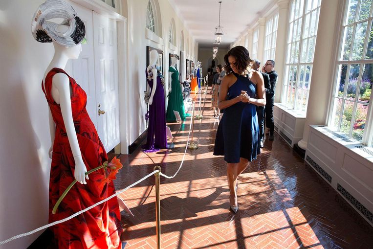 Michelle Obama bekijkt een tentoonstelling van haar jurken tijdens een modeworkshop in het Witte Huis. Beeld White House Photo