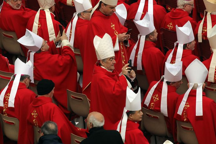 Moderne tijden: kardinalen in de weer met hun smartphone voor de ceremonie.