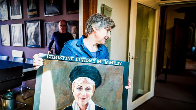 Corrie van Maris tijdens het vervangen van de oude portretten en het ophangen van de nieuwe vrouwenportretten in de Senaatskamer in de Universiteit Leiden Beeld Freek van den Bergh / de Volkskrant