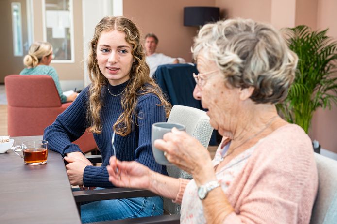 Lonneke praat met een van de senioren waarmee ze samenwoont.