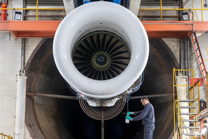 Een mecanicien tapt in de motortestcel van KLM op Schiphol brandstof uit een straalturbine.