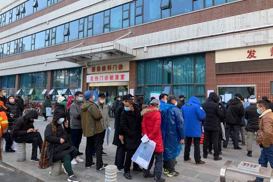 Mensen in de rij bij een koortskliniek aan een hospitaal in Wuhan.
