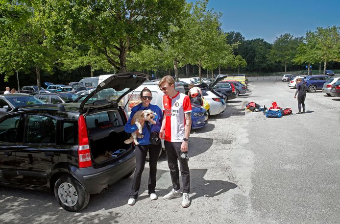 Maddie en Tom met hond Elton op de parkeerplaats aan de Eerste Slag, daarachter verkleden kitesurfers zich.