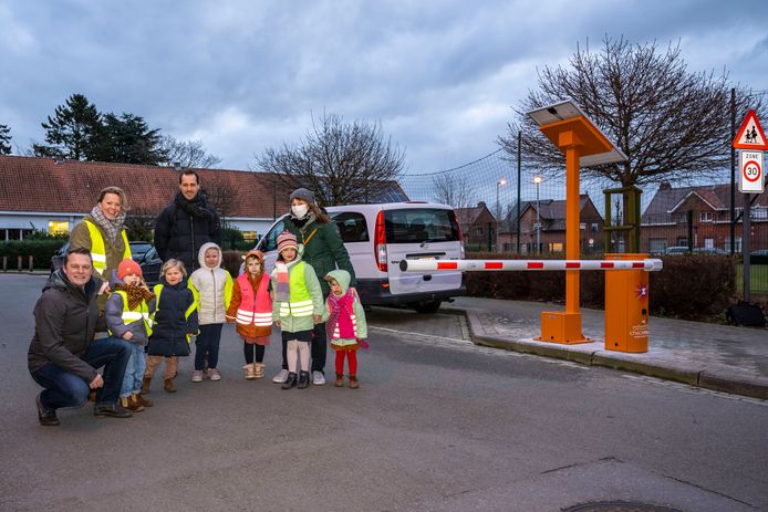 Een delegatie van het gemeentebestuur samen met de directeur en enkele leerlingen aan de slagboom van de nieuwe schoolstraat.