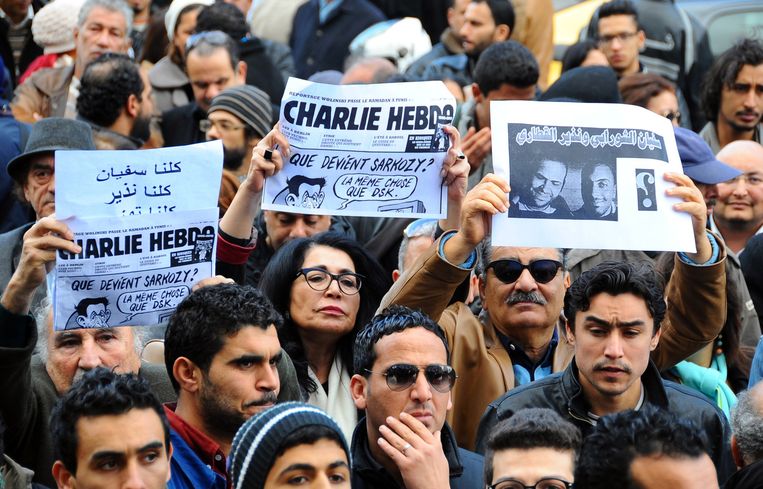 Mensen uit Tunesië houden kreten omhoog uit solidariteit met de slachtoffers van de aanslag op Charlie Hebdo. Beeld ap