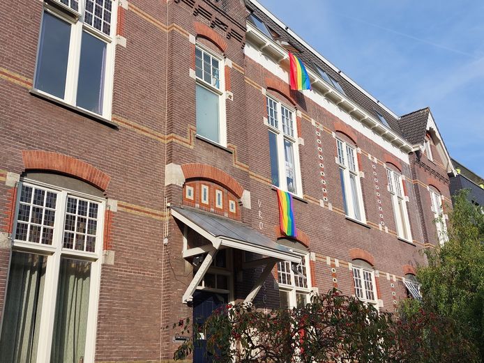 De regenboogvlaggen die aan het nabijgelegen pand hangen.