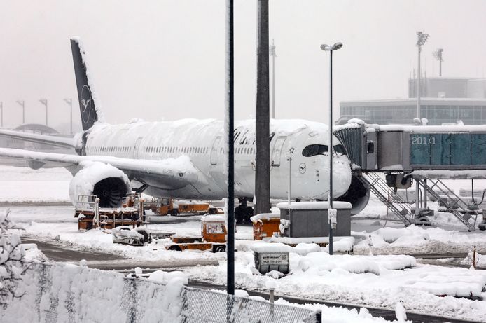 Een ondergesneeuw vliegtuig van Lufthansa op de luchthaven van München.