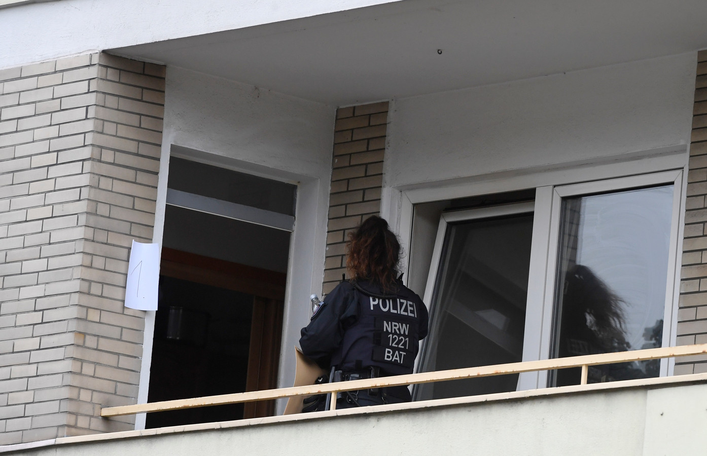 Een politieagent tijdens de huiszoeking in het appartement.