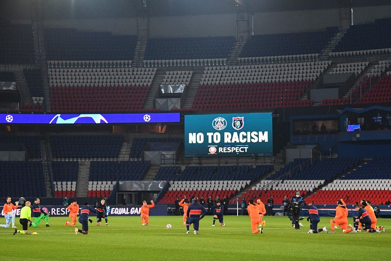 De spelers van PSG en Basaksehir knielen voor hun Champions League-match in Parijs. Beeld AFP