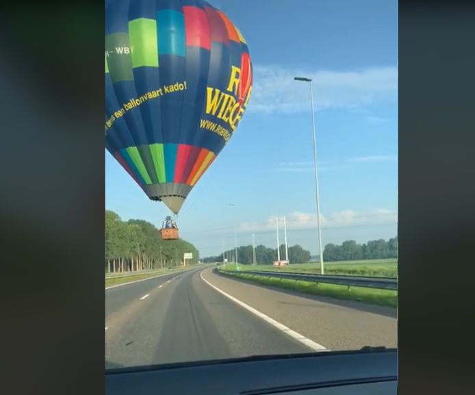 Een ballon van de Nederlandse ballonvaarder Rob Wiegers scheert vlak over een snelweg.