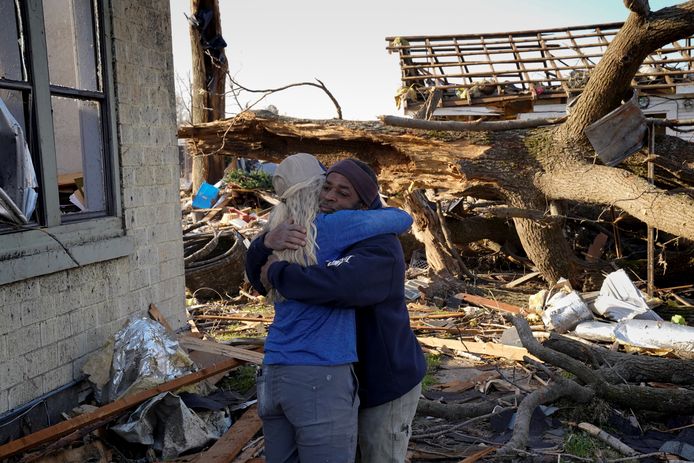 Twee vrienden omhelzeen elkaar in het plaatsje Wynne in Arkansas dat vrijwel van de kaart geveegd is geveegd door het noodweer.