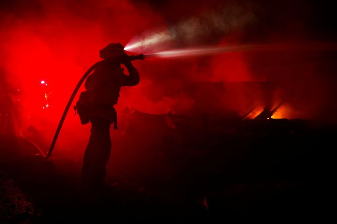 Een brandweerman probeert een huis te blussen dat bijna volledig vernield werd door de nieuwe brand in Californië, die de naam ‘Mill Fire’ kreeg.