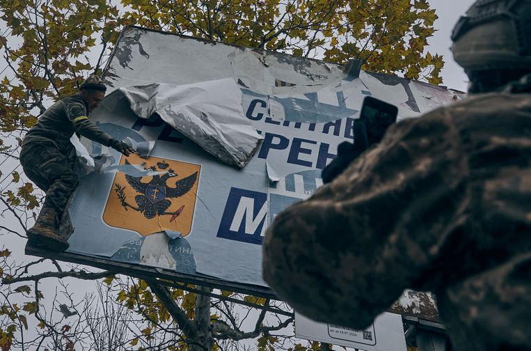 I soldati ucraini rimuovono un poster russo a Kherson, domenica.  immagine AP