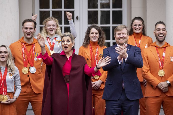 Koning Willem-Alexander en koningin Maxima poseren op het bordes van Paleis Noordeinde voor een groepsfoto met de medaillewinnaars van de Olympische Winterspelen 2022.