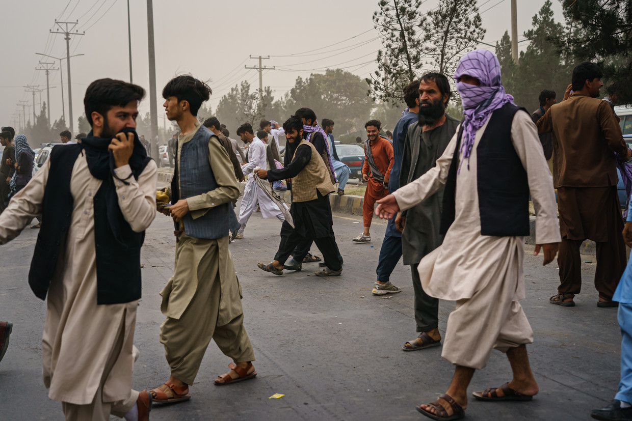 Afghanen op straat nabij de luchthaven van Kabul.  Beeld Los Angeles Times via Getty Image