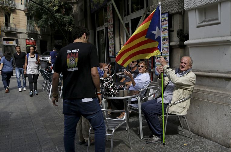 Een man houdt op een terras de Catalaanse vlag vast. Beeld reuters