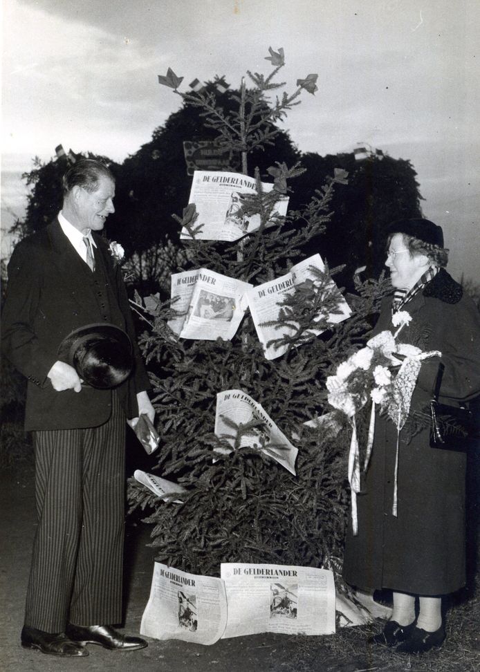 Toon Graven bij een kerstboom vol kranten.