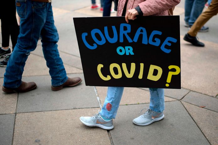 “Moed of Covid?” valt te lezen op het bord van een demonstrant.