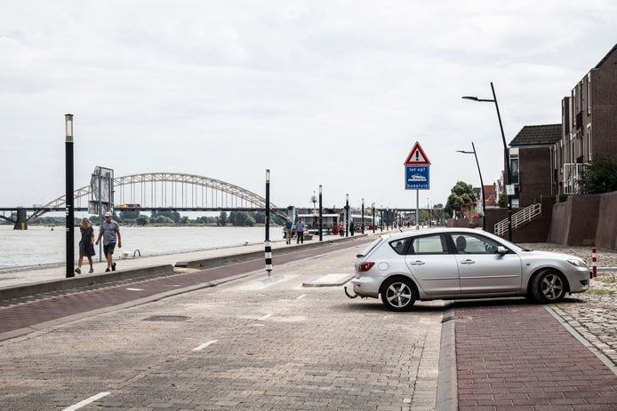 Een auto keert om bij een van de bussluizen op de Waalkade. Het westelijk deel van de Waalkade is verboden voor verkeer, vanwege de eerdere overlast.