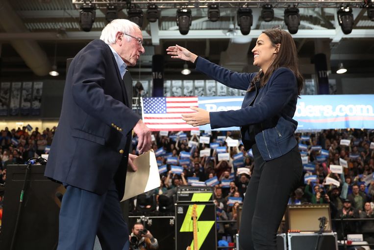 Alexandria Ocasio-Cortez en Bernie Sanders ontmoeten elkaar bij een campagne bijeenkomst van Sanders. Beeld AFP