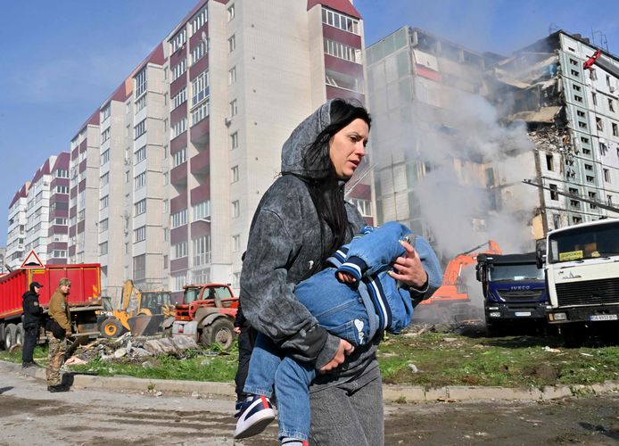 Voor het eerst in 51 dagen werd Kiev opnieuw gebombardeerd. Een vrouw loopt weg met een kind in haar armen.