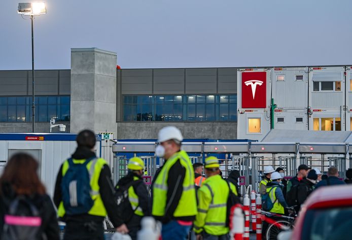 Werknemers van Tesla aan de ingang van de toekomstige accufabriek van Tesla nabij Berlijn.