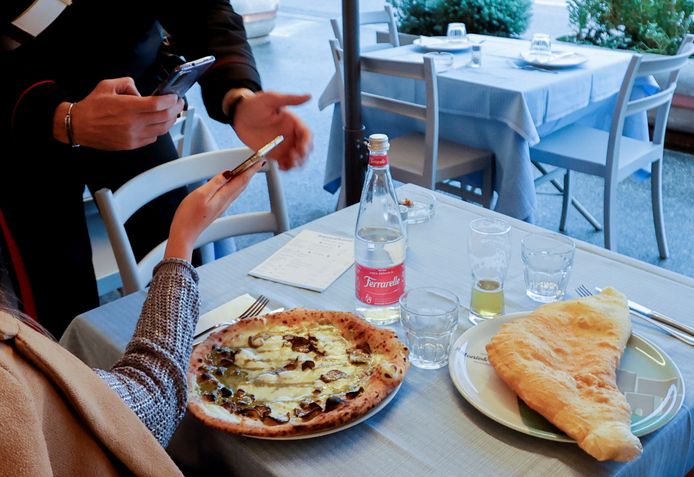 Een agent controleert de coronapas van restaurantbezoekers in Napels.