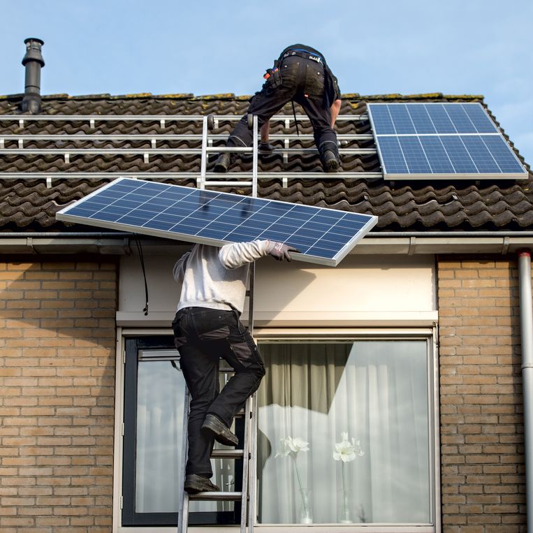 Op het dak van een huis in Drachten worden zonnepanelen geplaatst. Beeld ANP