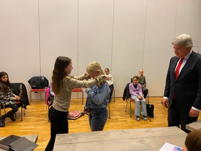 De nieuwe kinderburgemeester Emma krijgt de ambtsketen omgehangen door haar voorgangster Lisa.