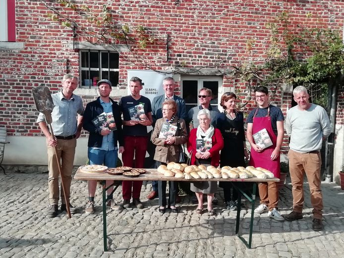 De ovenbouwers, bewoners van de Tympelhoeve en mensen van Regionaal Landschap presenteren de taarten en broodjes voor het bakhuis