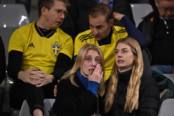 Geschokte Zweedse fans op de tribunes horen dat de wedstrijd niet wordt uitgespeeld.