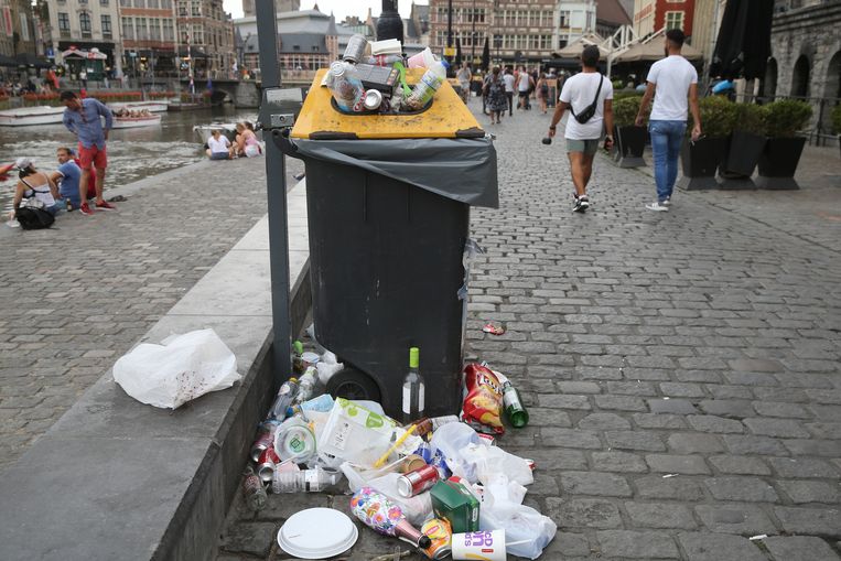 Overvolle vuilnisbakken op de Graslei. Zwerfvuil is één van de grootste frustraties bij de Gentenaren. Beeld Gianni Barbieux