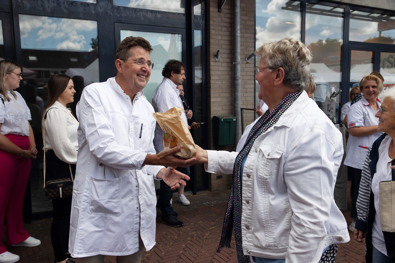 Huisarts Peter van Bommel krijgt verse kersen van marktbezoekster Jaan Jansen-Abrahams uit Hooge Mierde.