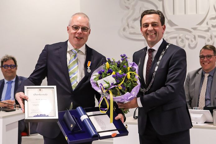 Klaasjan de Jong krijgt bij zijn afscheid van de gemeenteraad een koninklijke onderscheiding opgespeld door burgemeester Michel Bezuijen.